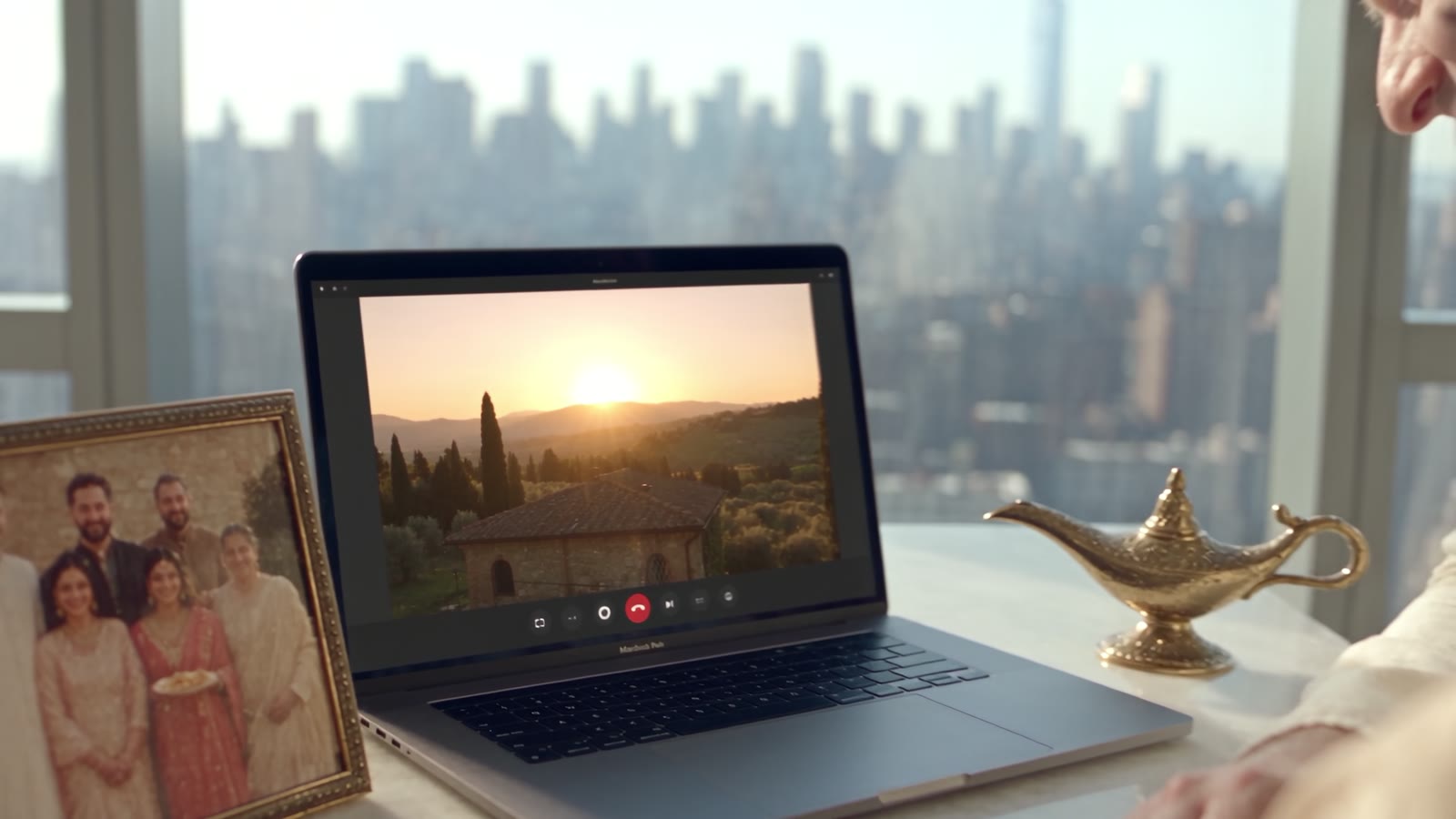 Una coppia a un tavolo con il computer, sullo schermo una villa e la campagna