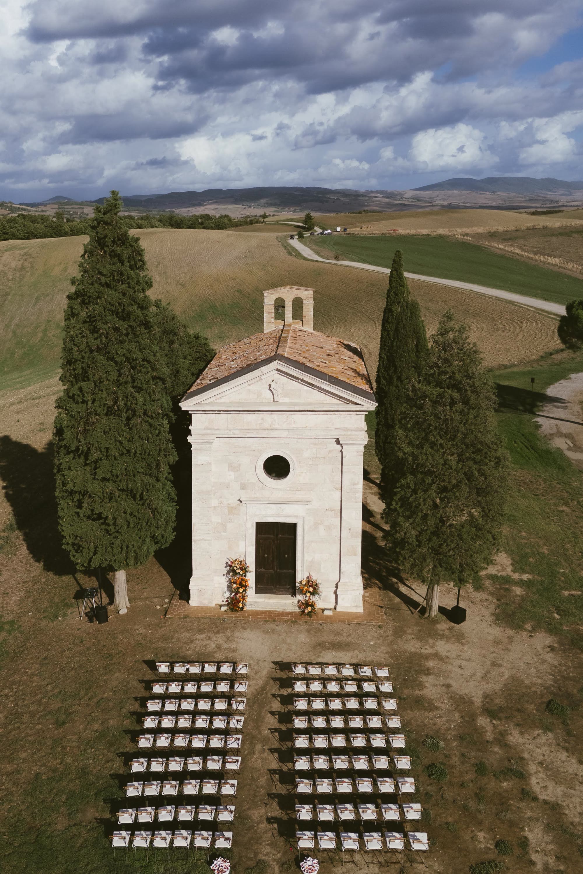 La cappella di Vitaleta vista dall'alto, fra i cipressi, con gli invitati che si radunano