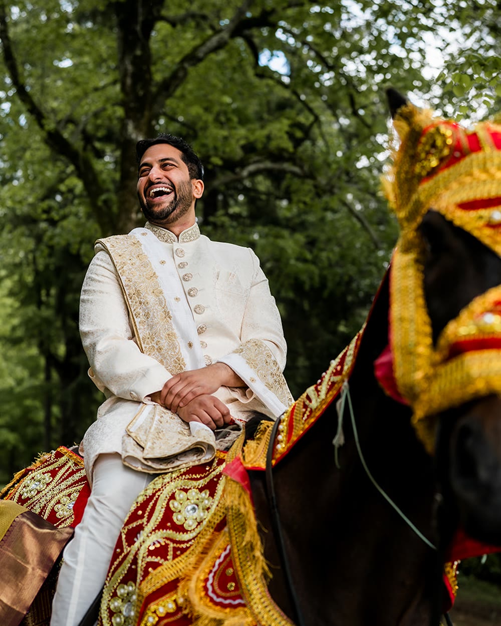 The groom arriving on a decorated horse with the baraat