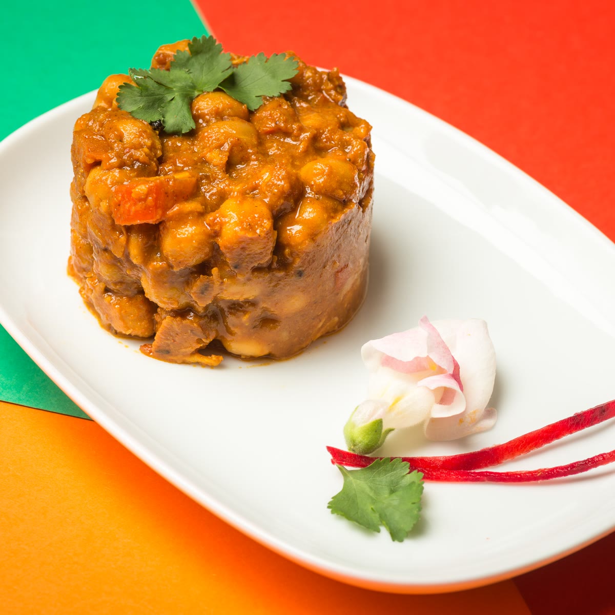Chana masala with coriander and a carrot flower