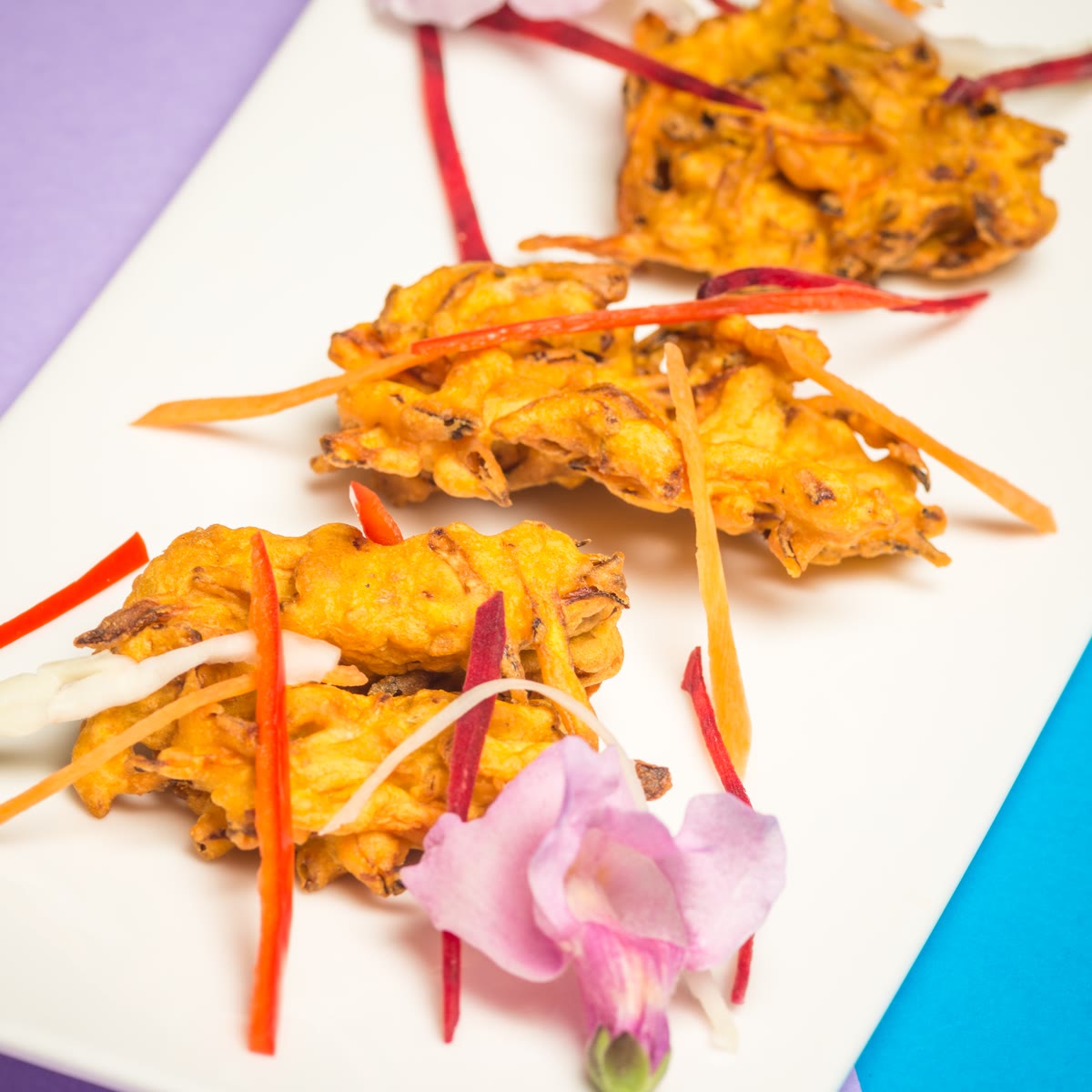 Vegetable pakora with shredded carrot and a flower